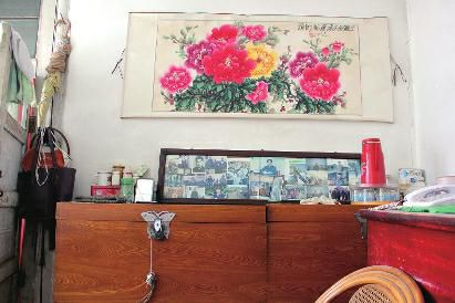 　陳會英將兒女的照片都裱起來，裝在一個大相框里，放在箱子上經(jīng)?？?，其中最多的就是劉金國的照片。