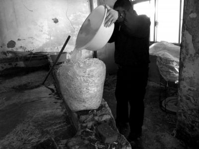 作坊內(nèi)工人用攪拌有漂白粉的藥水給豆芽增白。