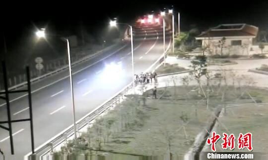 看到車輛經(jīng)過，孩子們便急忙跑到一旁的花圃上?！【焦﹫D　攝