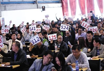 競拍者正在練習(xí)舉牌動作，以便拍賣時讓工作人員看清號牌。