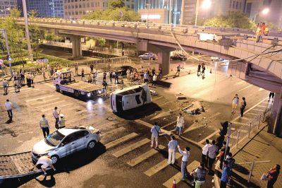 路虎沖下國貿(mào)橋砸中一輛起亞轎車，橋上厚達(dá)幾十厘米的水泥護(hù)欄被撞斷，碎石四處散落，數(shù)十群眾在現(xiàn)場圍觀。