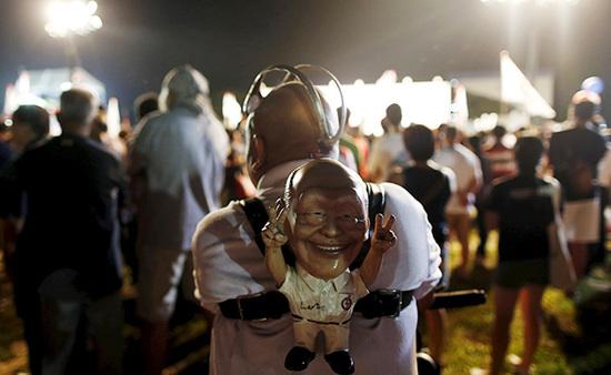 9月4日，新加坡，執(zhí)政黨的一場集會上，一名支持者背著一個李光耀的人偶。