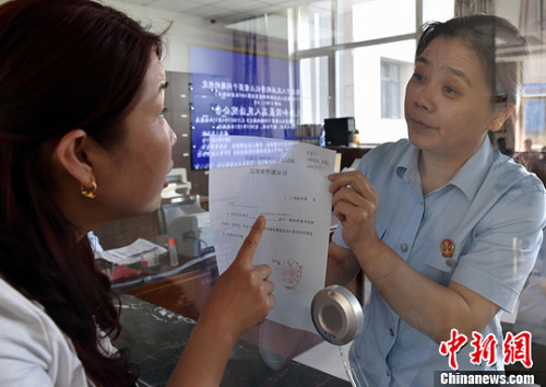 資料圖：2015年5月4日，河北石家莊市橋西區(qū)人民法院立案庭庭長(zhǎng)齊燕正在為立案人辦理相關(guān)手續(xù)，完成整個(gè)過程只用了5分鐘。當(dāng)日是立案登記制改革首個(gè)工作日，該院共立案36件，立案率達(dá)到90%。中新社發(fā) 翟羽佳 攝