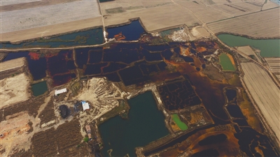 4月19日，廊坊市大城縣南趙扶鎮(zhèn)，津保路以北約八九百米處，一個(gè)巨大的污水坑中，水體呈現(xiàn)紅褐色。 新京報(bào)記者 尹亞飛 攝