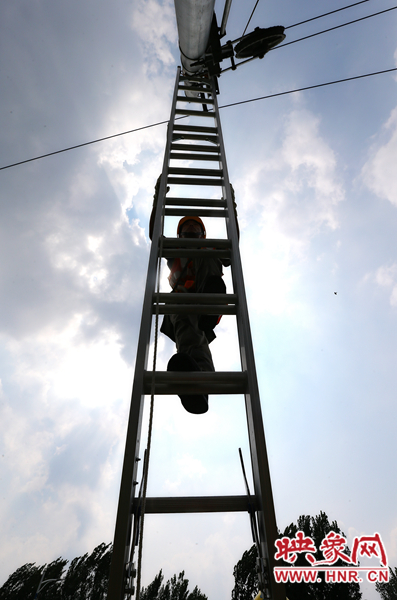 頂著太陽(yáng)的直射，檢修工不斷要爬上高處施工