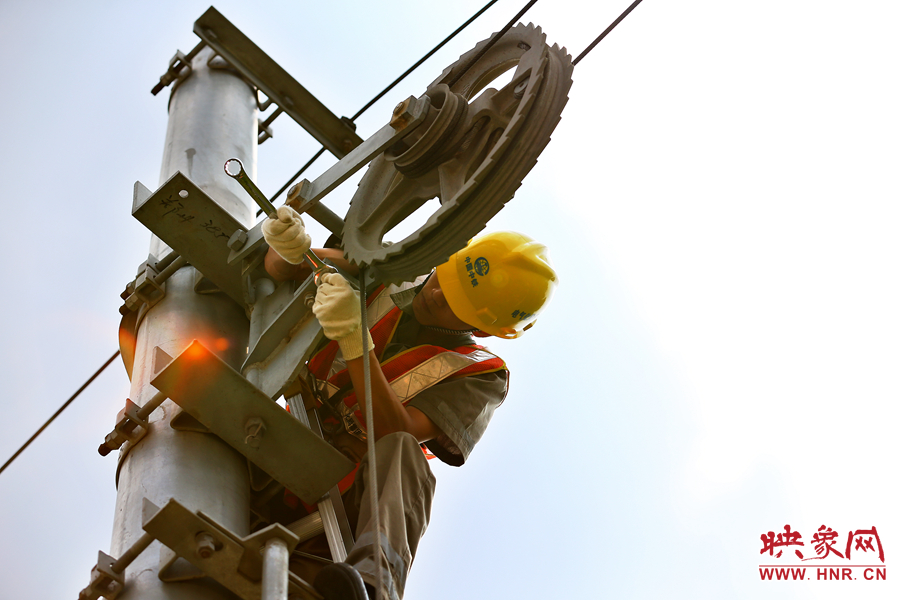 被太陽(yáng)暴曬后的線桿碰著就能燙紅皮膚，可是檢修員此刻也顧不得許多