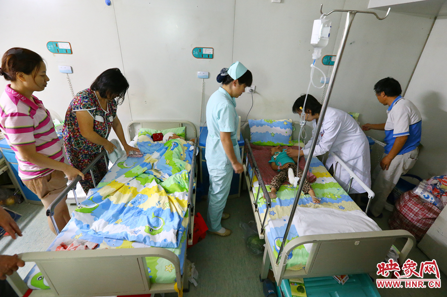 手術(shù)前，畫面右側(cè)的大龍正在接受醫(yī)生的檢查，左側(cè)的小龍還在熟睡。