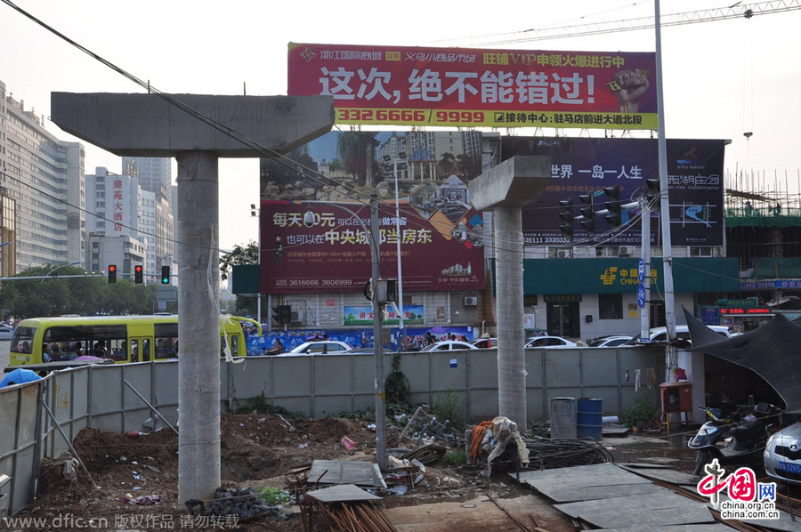 過(guò)街天橋一側(cè)的橋樁早已打好,可是對(duì)面的郵政銀行網(wǎng)點(diǎn)依舊在照常營(yíng)業(yè)。