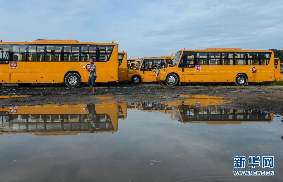 8月29日，溫嶺市城西街道芷勝莊村一名小男孩從閑置的校車邊走過(guò)。