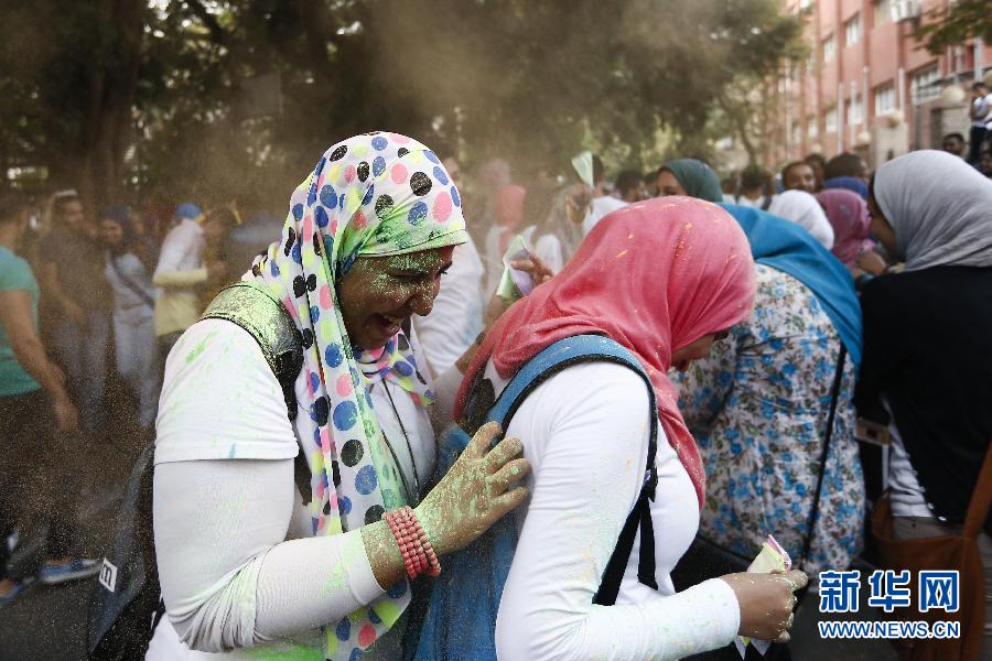 10月16日，在埃及首都開羅，兩名女青年在“彩色跑”活動(dòng)中躲避人們拋撒的彩色粉末。