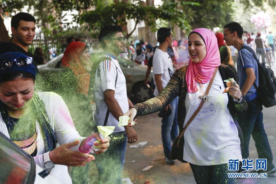 10月16日，在埃及首都開羅，一名女青年在“彩色跑”活動(dòng)中拋撒彩色粉末。