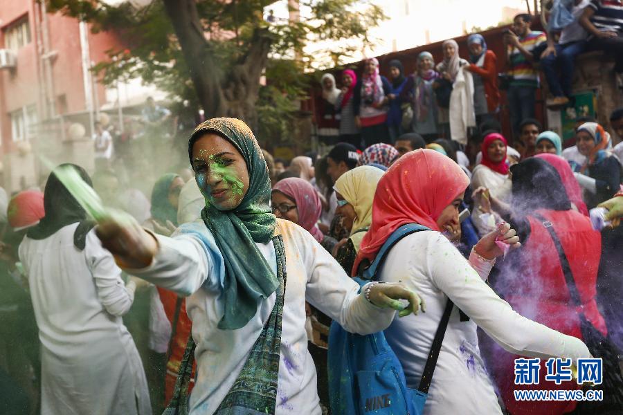 10月16日，在埃及首都開羅，一名女青年在“彩色跑”活動(dòng)中拋撒彩色粉末。