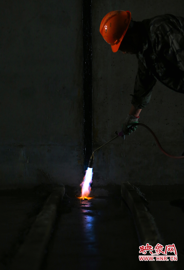 工人師傅用噴槍烘干地面，便于做防水處理