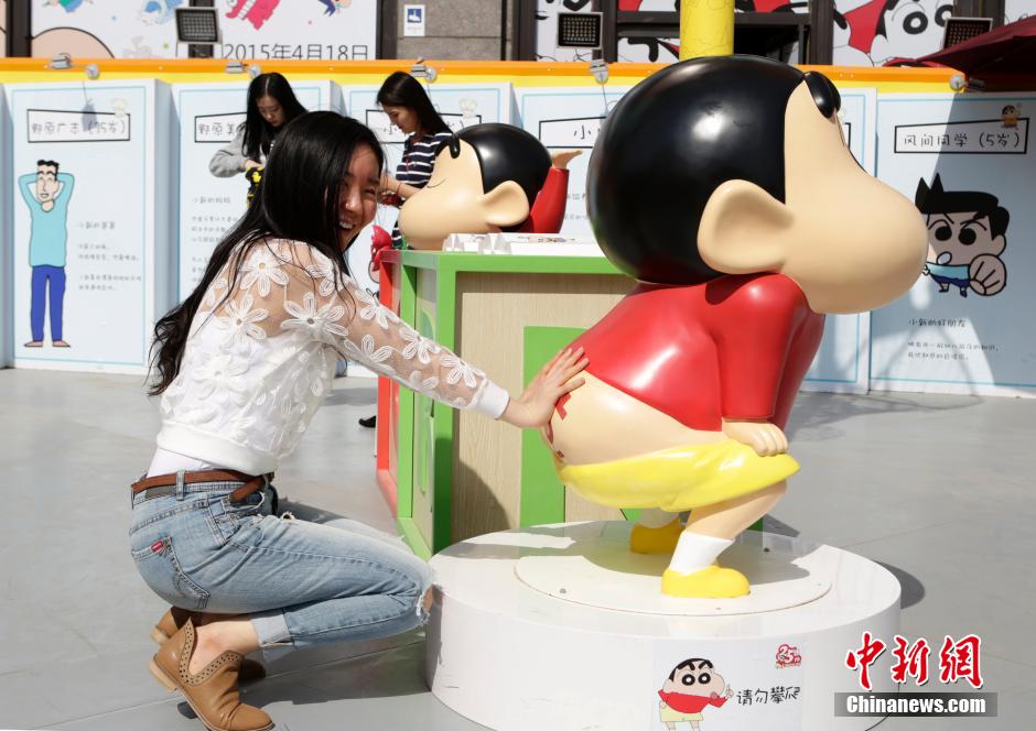 4月22日，游客與蠟筆小新合影?！跋灩P小新25周年紀(jì)念特展”日前在北京開展，吸引了不少市民游客。