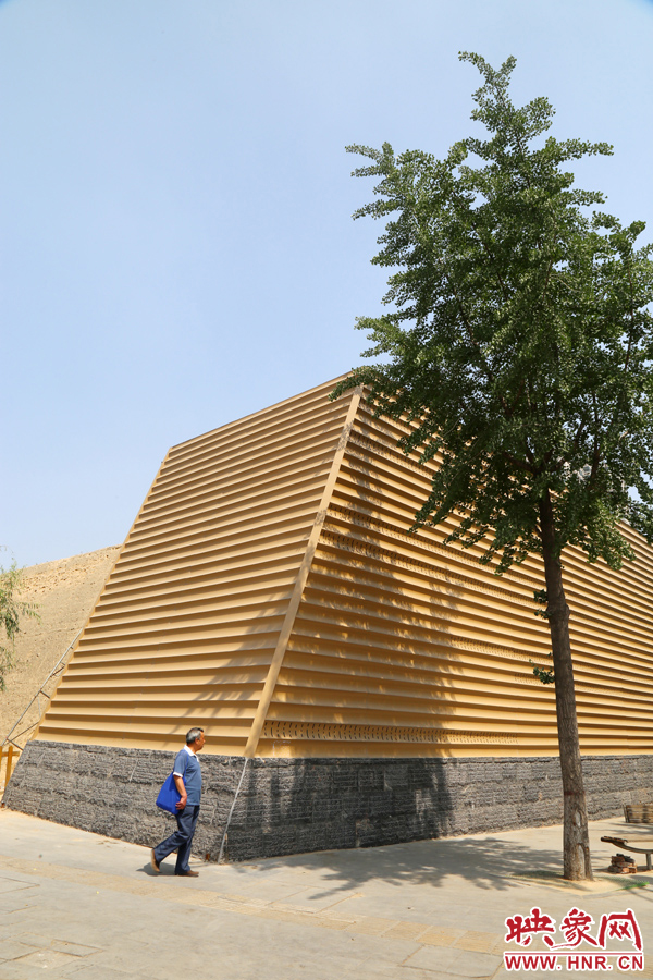 一名路人從“土豪金”保護(hù)殼前經(jīng)過。