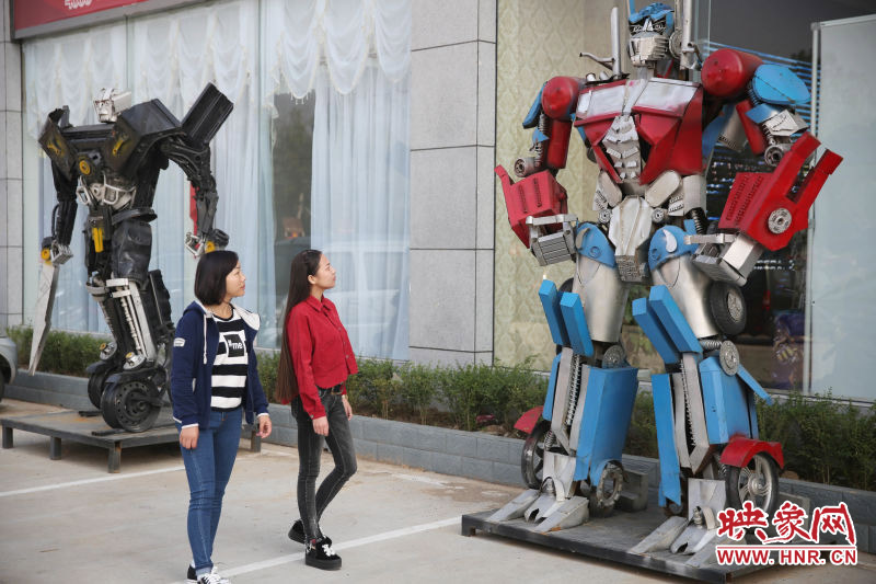 10月14日，市民在參觀河南省平頂山市寶豐縣一家企業(yè)門(mén)前的“變形金剛”。