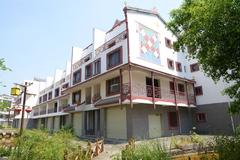 2016年7月26日，村民在廣西來賓市忻城縣隆達(dá)山水福城荒廢別墅間放牛。