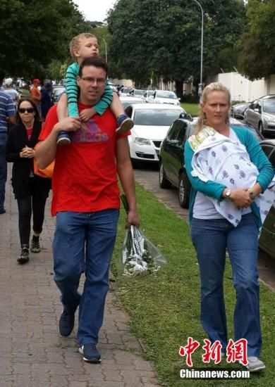 圖為一個白人家庭，由父母帶著孩子到曼德拉家門外悼念。中新社發(fā) 宋方燦 攝