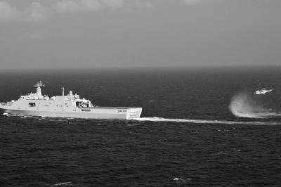 11日，抵達馬航飛機失聯(lián)海區(qū)的海軍井岡山艦與艦載直升機協(xié)同展開立體搜救行動。新華社發(fā)