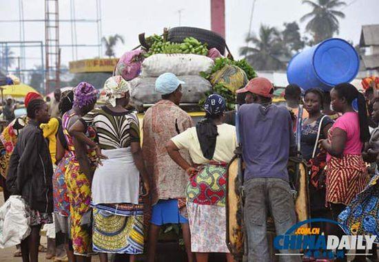 當?shù)貢r間2014年8月14日，利比里亞蒙羅維亞，市場里的商人們圍著一輛汽車。