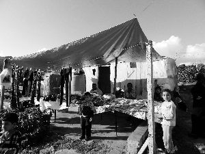 黎巴嫩一敘利亞難民營(yíng)，難民支起攤鋪賣衣服掙錢。