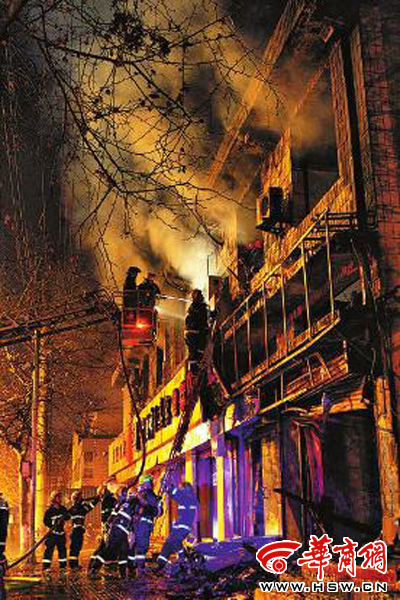 昨日22時(shí)10分，西安市豐慶路南小巷南口，消防官兵架梯子登上二樓施救 本組圖片由本報(bào)記者 閆文青 攝