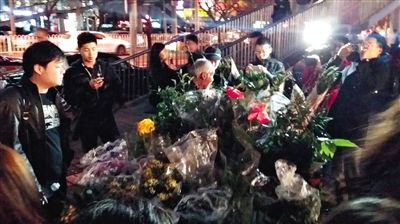 昨晚7時(shí)許，三里屯太古里西邊附近一過(guò)街天橋旁邊，聞?dòng)嵍恋木W(wǎng)友圍住了賣花老人，爭(zhēng)相買花。 網(wǎng)友“行者橙子”供圖