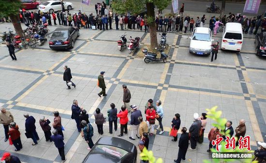 圖為10月28日，在江西九江市一家羊絨皮草服裝服飾博覽會現(xiàn)場，老人們正在頂著寒風(fēng)排隊等待領(lǐng)取10元代金劵。