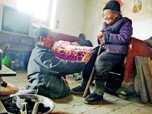 52歲的劉蘭山每天靠爬行照顧90歲的老母親。孫國(guó)祥 攝