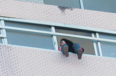 28樓的窗臺(tái)上坐著一名女子，其兩條腿耷拉在室外，不停地?cái)[動(dòng)。