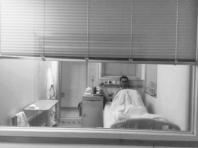 楊杰在醫(yī)院隔離病房中，沖記者揮了揮手。