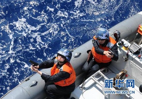 　3月28日，十余名臨檢拿捕隊員乘小艇駛至模擬可疑商船下方水面。