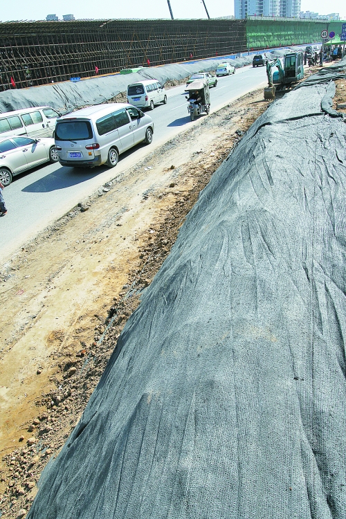 豐樂路與北三環(huán)交叉口，修路的土被歸置得整整齊齊，并用黑網(wǎng)覆蓋，既保暢通又避免了揚塵。