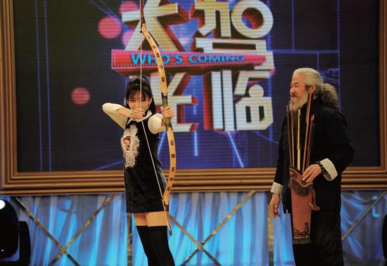 楊福喜（右）現(xiàn)場指點(diǎn)演員射箭