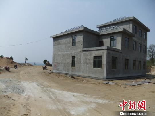 鴨河水庫庫區(qū)邊的新建別墅，一面墻上寫著“拆”，另一邊在加緊施工。吳揚　攝