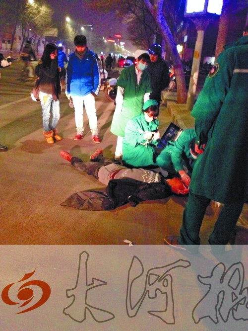 醉漢躺在地上，醫(yī)護(hù)人員對(duì)其進(jìn)行檢查。